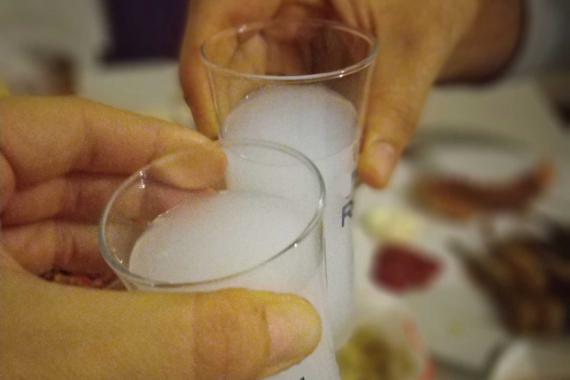 Rakı dolu kadehleri birbirine tokuşturan iki el