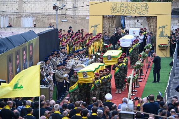 Hizbullah üyelerinin cenaze törenleri, sarı renkli bezlere sarılmış tabutlar