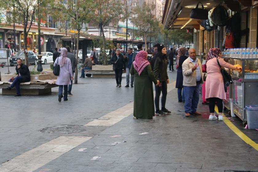 Diyarbakır'de caddede yürüyen, dükkanların önünde gündelik yaşantılarına devam eden yurttaşlar.