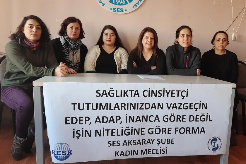 SES Aksaray Şube üyesi sağlık emekçisi kadınlar, 'Sağlıkta cinsiyetçi tutumlarınızdan vazgeçin. Edep, adap, inanca göre değil işin niteliğine göre forma' yazılı pankartın arkasında açıklama yaparken