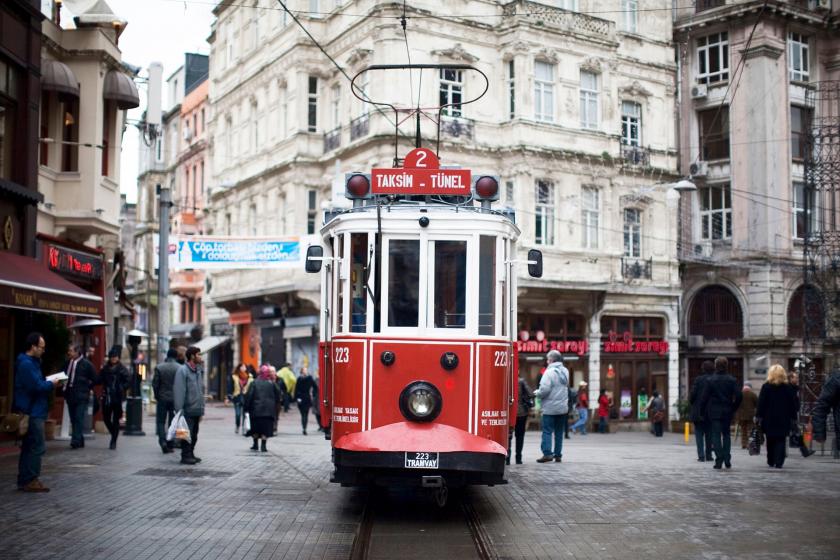 Beyoğlu caddesinde ilerleyen nostaljik tramvay ve caddede yürüyen insanlar.