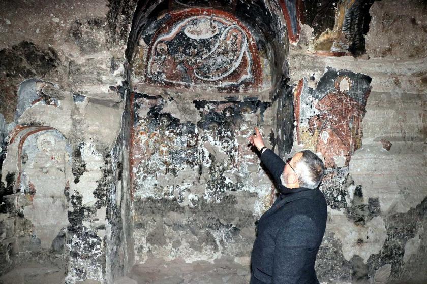 Muhtar, Beşaret Kaya Kilisesi'nin duvarlarda bulunan tahrip edilmiş freskleri gösteriyor. 