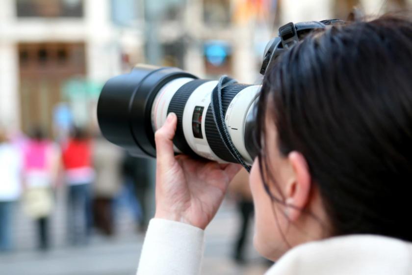 Fotoğraf makinesi ile fotoğraf çeken bir kadın