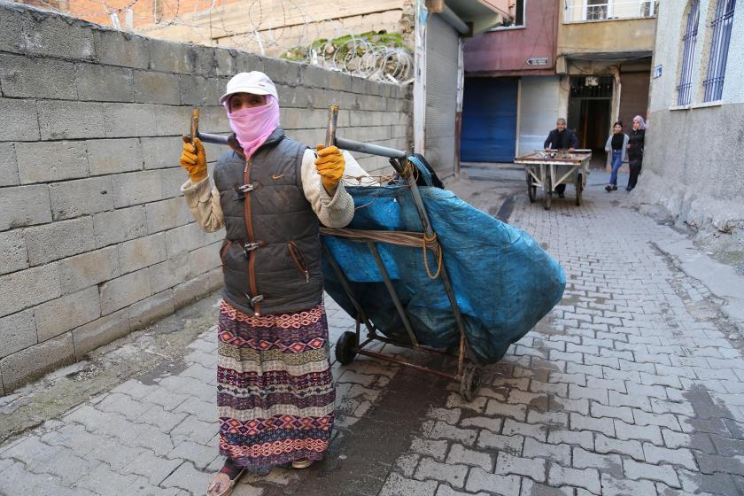 arkasında çekçek arabasıyla plastik toplayan kadın.