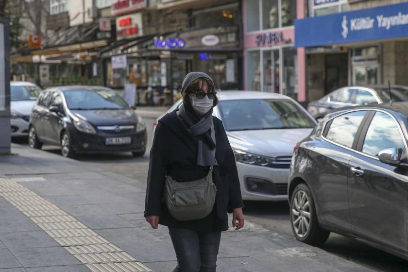 Ankara'da tenha caddede ağzı ve burnu kapalı halde yürüyen bir kadın.