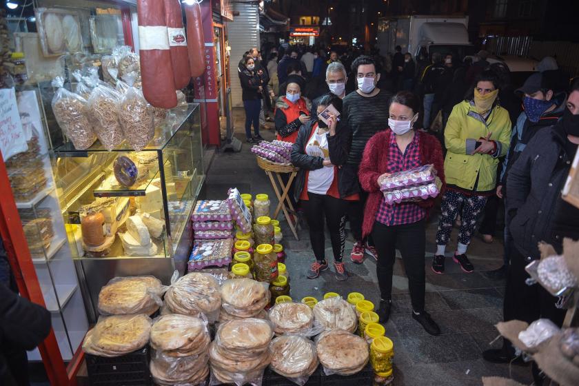 (Solda) market, markete girmek için sırada bekleyenler (sağda)