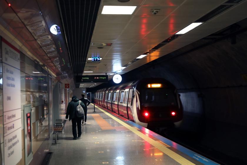 İstasyona yaklaşan metro treni ve bekleyen yolcular.