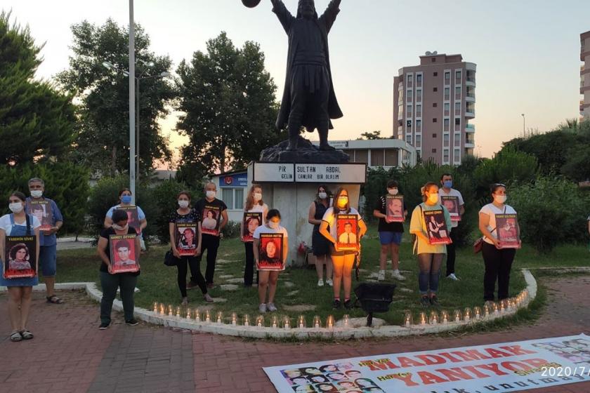 Narlıdere'deki Pir Sultan heykeli önünde ellerinde Sivas Katliamında yitirilenlerin fotoğrafları bulunan çok sayıda kişi