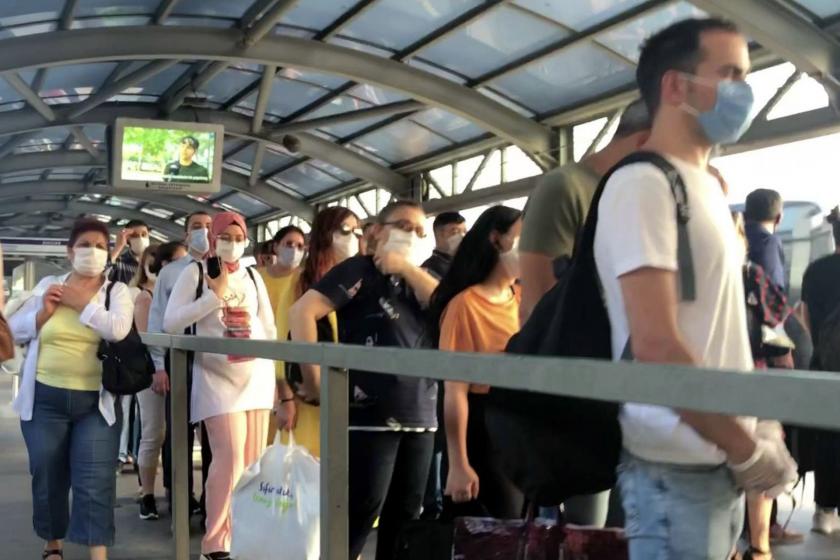 metrobüs durağında sırada duran insanlar