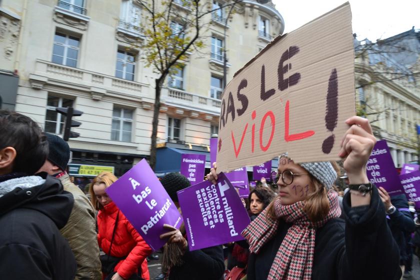 Paris'te cinsel saldırıya karşı bir eylemde yürüyen kadınlar ve tecavüz karşıtı pankart.