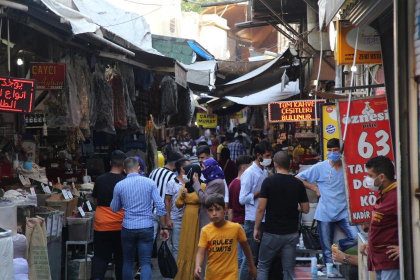 Urfa'da çarşıda yürüyen insanlar, sağda ve solda dükkanlar ve önünde bekleyen esnaf