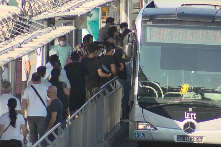 Kalabalık bir metrobüs durağında maskeli insanlar