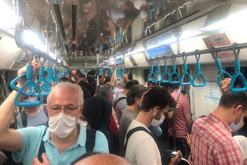 Kalabalık bir metro vagonunda maskeli insanlar