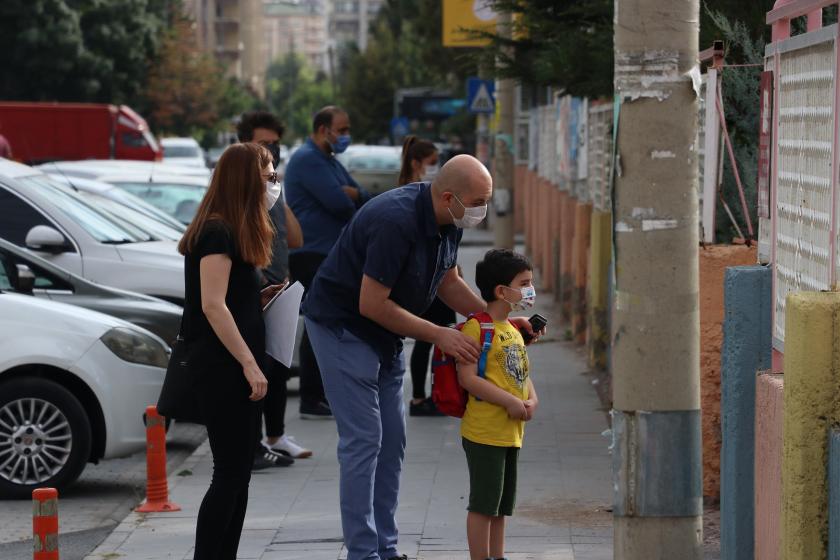 Yüz yüze eğitimin ilk gününde okul bahçesine çocuğunu gönderen bir baba.