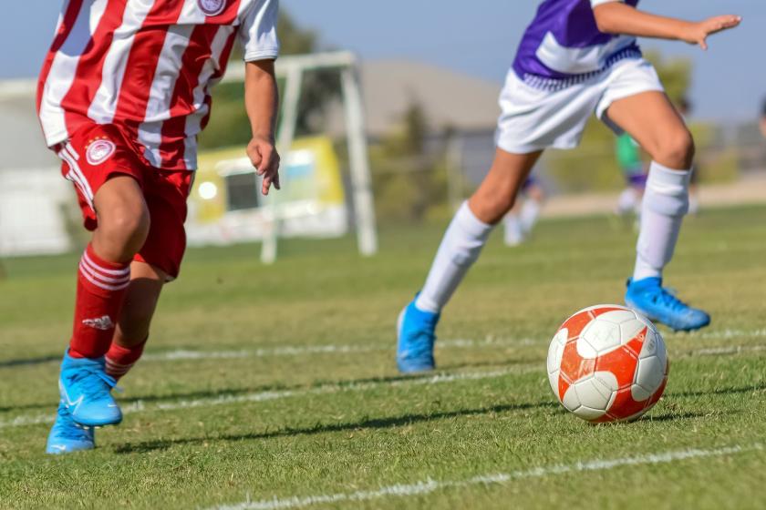 Bir futbol müsabakasında mücadele eden iki futbolcu.