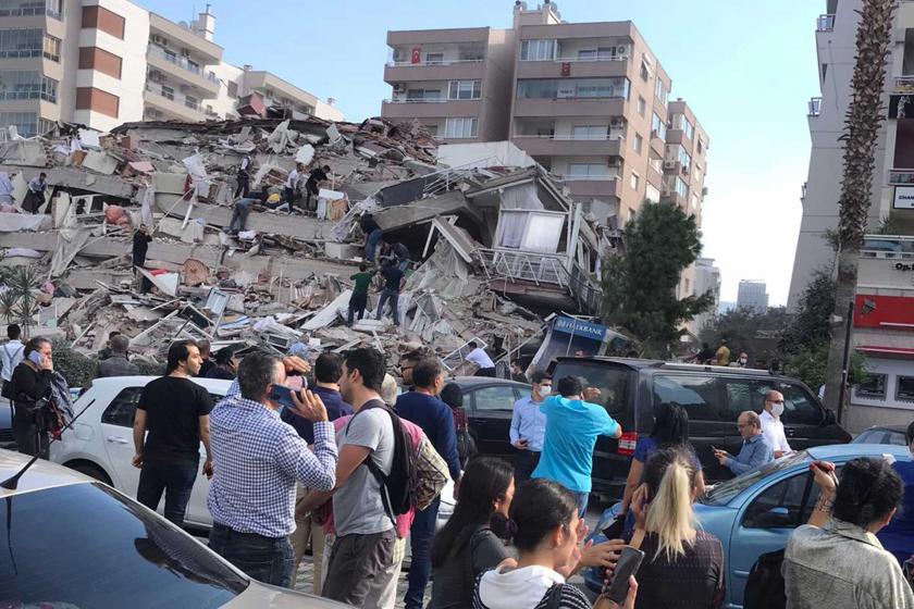 İzmir'de meydana gelen depremin ardından yıkılan bir bina (solda) ve çevresinde bekleyen yurttaşlar