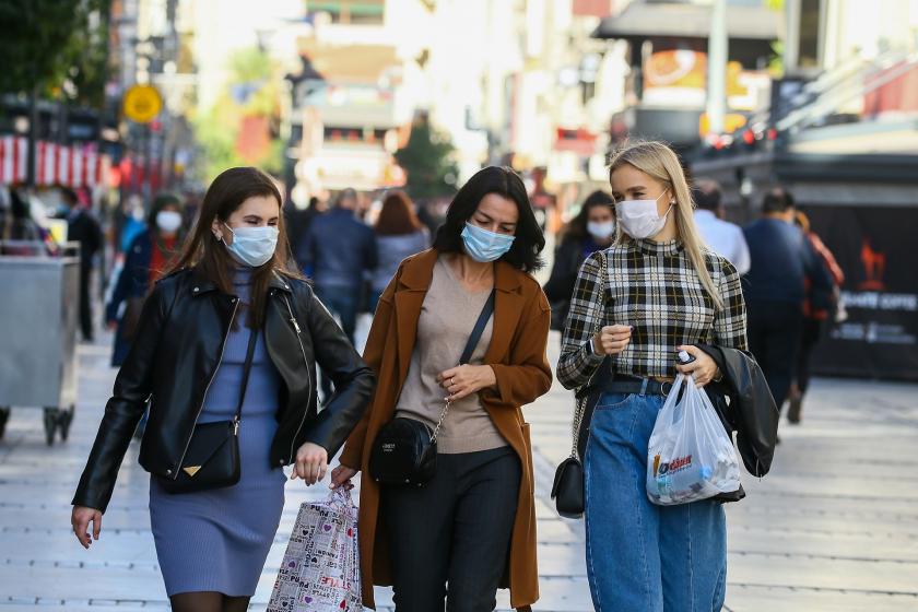 Koronavirüs (Kovid-19) salgınına dair alınan tedbirler neticesinde İzmir'de sokakta cerrahi maske ile yürüyen insanlar.