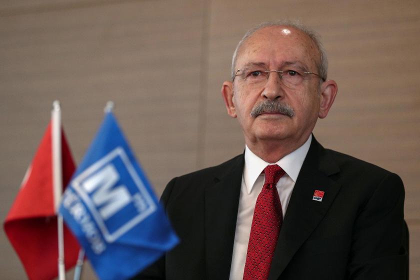 Kemal Kılıçdaroğlu, sağ tarafına bakıyor, önündeki kürsüde bayraklar var