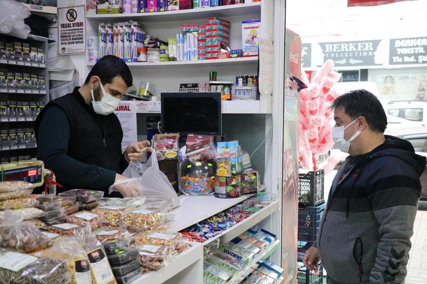 Bakkal işleten kişi (solda) alışveriş yapan kişi (sağda)