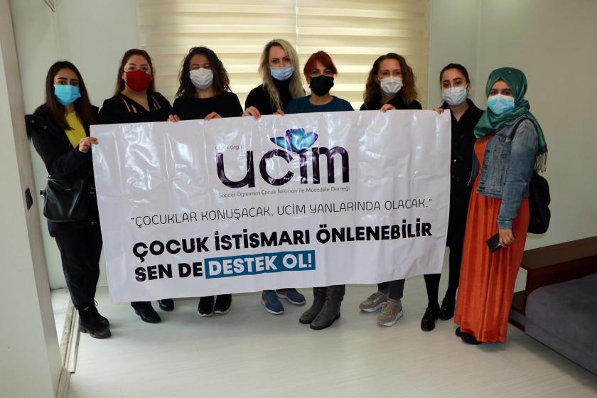 Çocuk istismarına karşı pankart tutan kadınlar