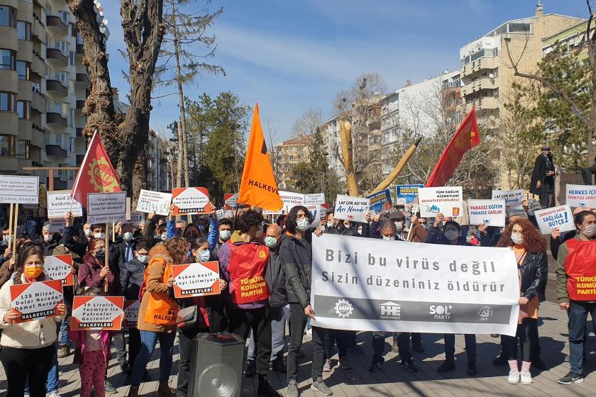 Bizi bu virüs değil sizin düzeniniz öldürür yazılı pankart ve arkasında eyleme katılanlar