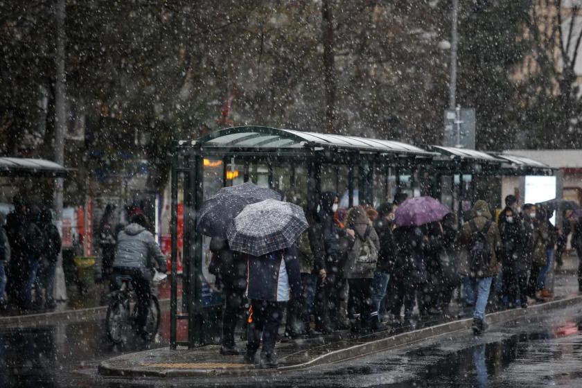 İstanbul'da kar yağışı sırasında durakta bekleyen insanlar