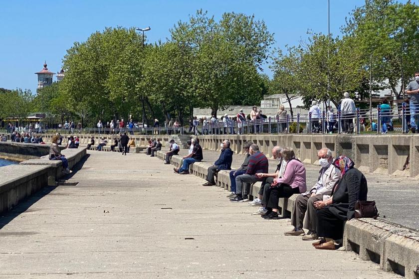 Güneşli havada sahilde oturanlar