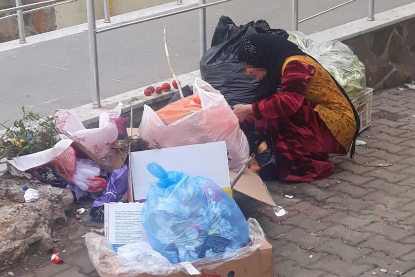 Çöplerin arasından yemek ayıklayan bir kadın