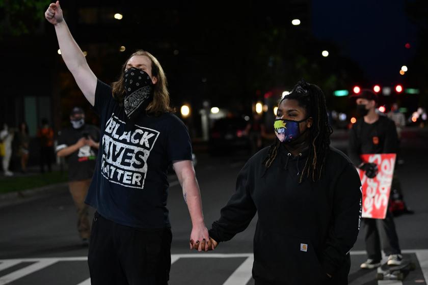 ABD'de Black Lives Matter eylemine katılan beyaz bir erkek (solda) ve siyah bir kadın (sağda)