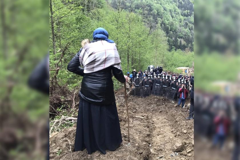 ikizderede bir kadın tepelik bir yerde değneğine yaslanarak aşağıdaki jandarmaya bakıyor. 