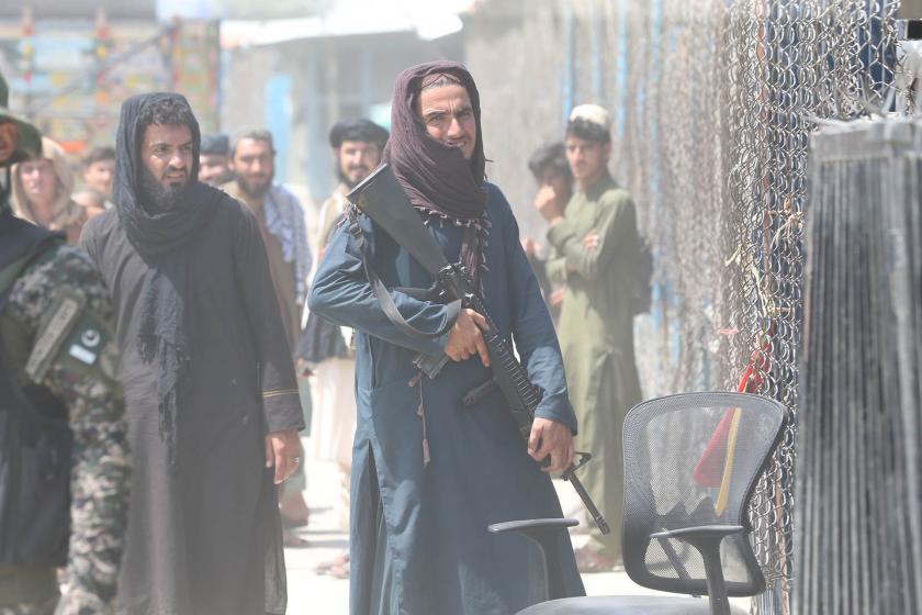 Taliban üyesi elinde silahla bekliyor