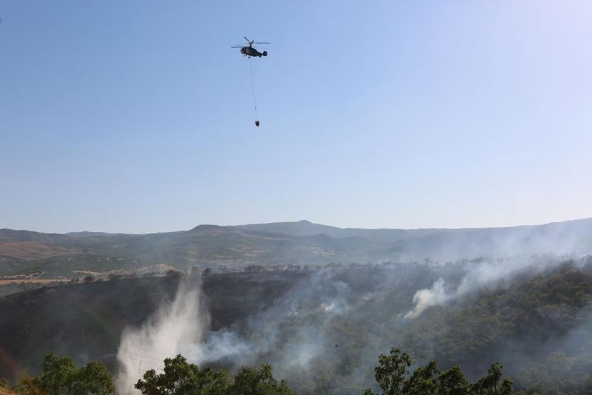 Yangın ve gökyüzünde bir helikopter