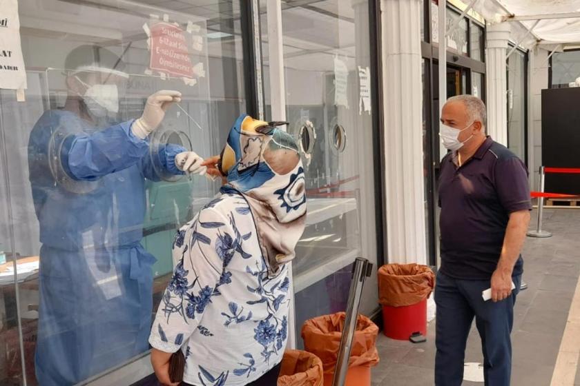 PCR testi yapan görevli ve yaptıran bir kadın