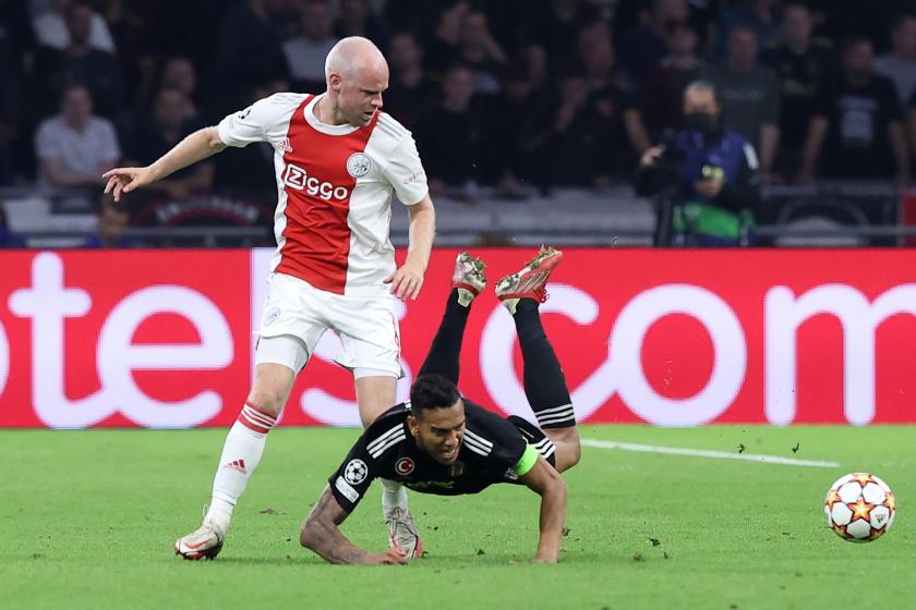 Ajax'lı oyuncu ayakta, yerde kolları üzerine düşen Beşiktaşlı oyuncu.