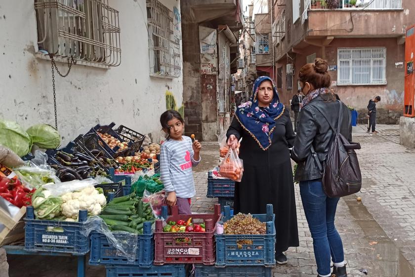 Manavın önünde kadınlarla sohbet eden muhabir