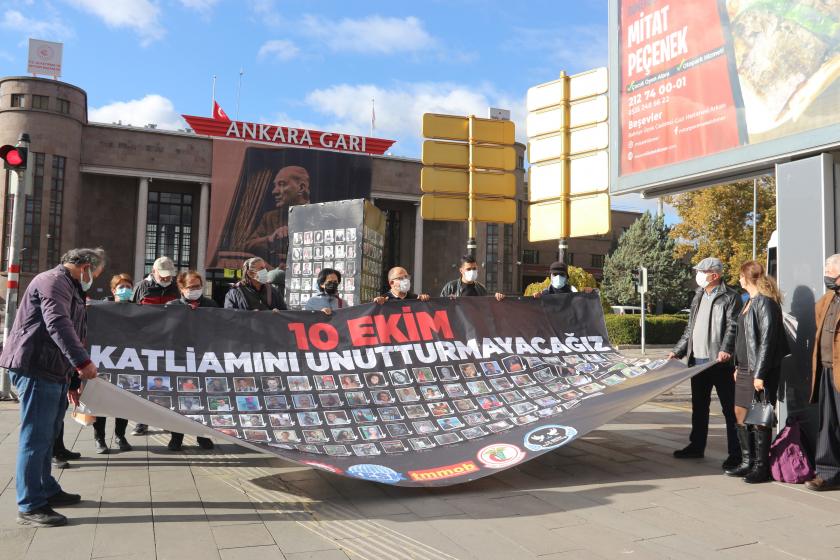 Ankara Garı önünde 10 Ekim Katliamı'nda yakınlarını kaybedenler ve yaralıların basın açıkamasından görüntüler, hayatını kabedenlerin fotoğraflarının bulunduğu pankart ve arkasında katılımcılar 