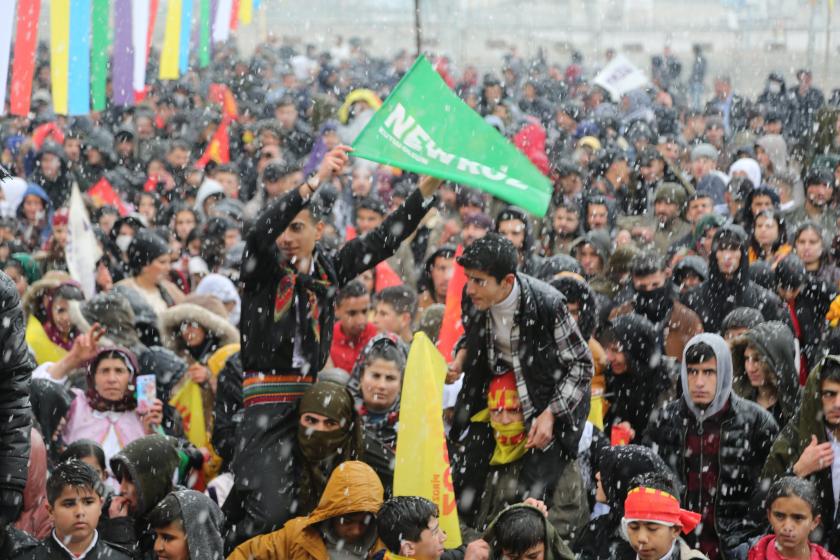 Şırnakta Newroz alanında insanların omuzları üstüne çıkıp bayrak sallayan iki  genç