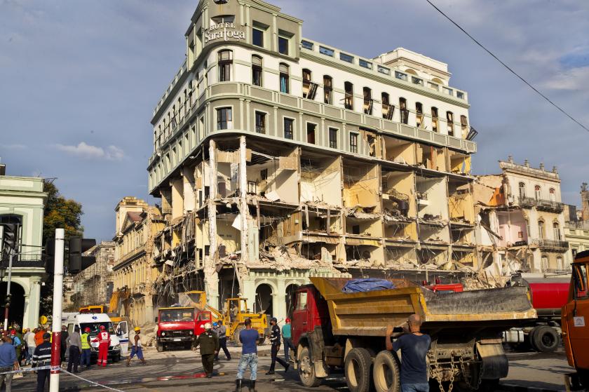 patlama sonucu hasar görmüş olan otel çevrede iş makinaları ve insanlar