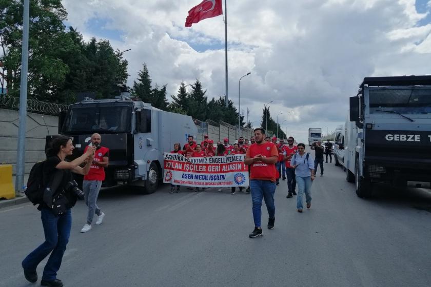 İşçiler iki yana park etmiş TOMA'ların arsında slogan atarak geçiyor