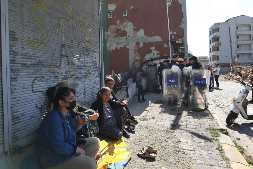 Sokakta oturan mahalleli kadınların arkasında kalkanlı çevik kuvvet polisleri