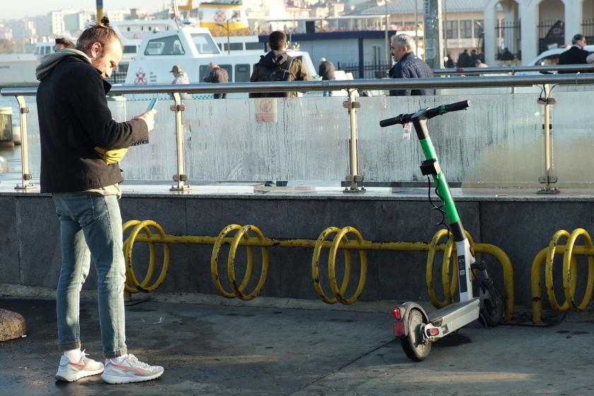 Elektrikli scooterı park etmek için fotoğrafını çeken kullanıcı