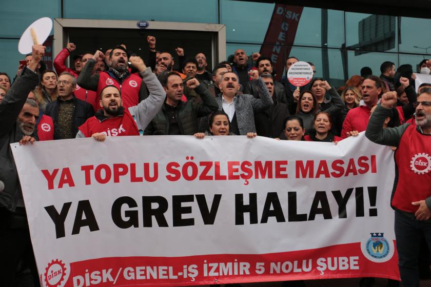 işçiler grev pankartıyla slogan atıyor