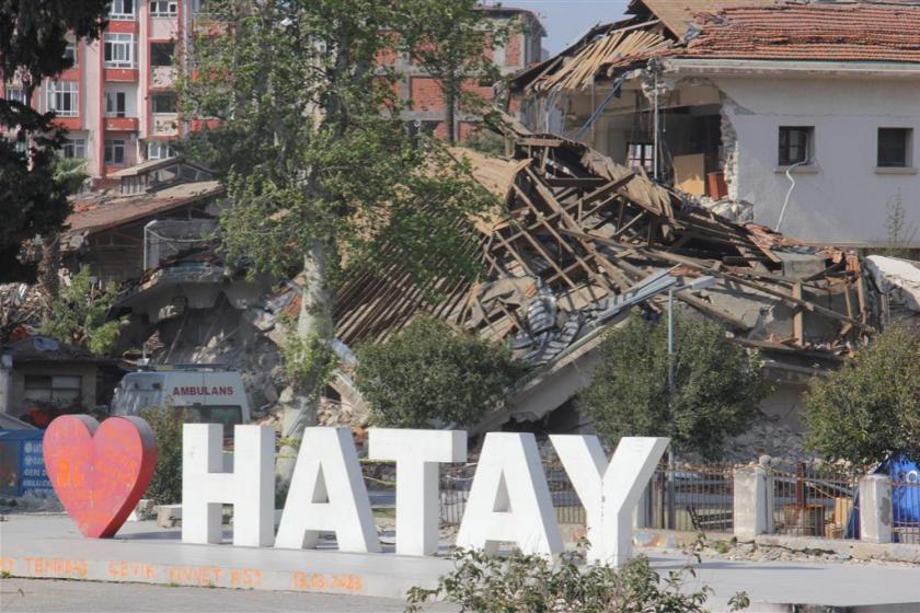 Hatay yazısının arkasında yıkılmış binalar. 