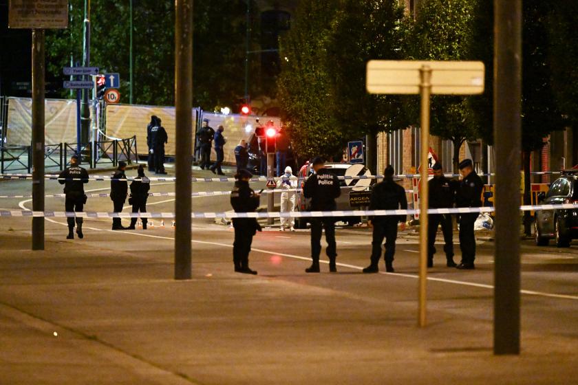 polis şeridi ile çevrelenmiş cadde ve olay yerinde araştırma yapan polisler 