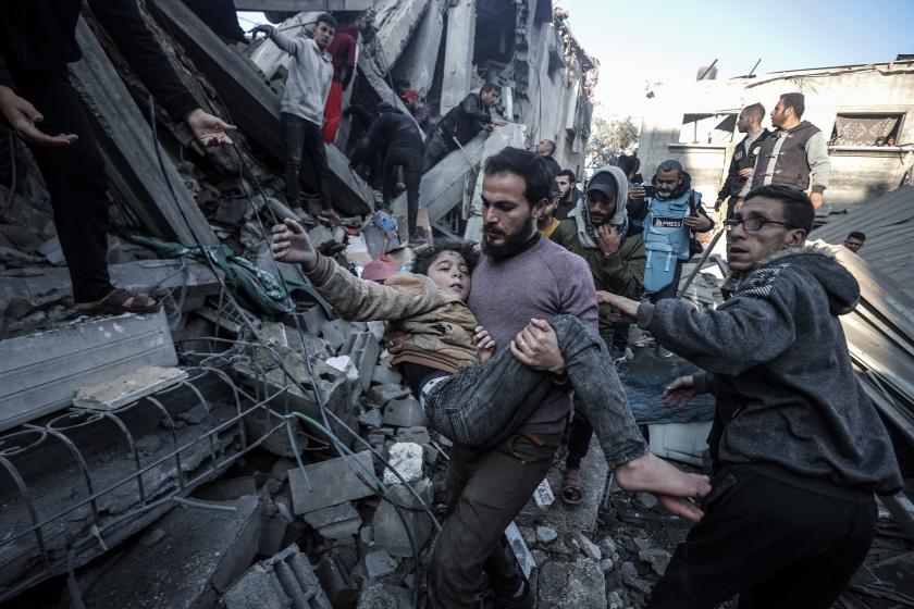 İsrail'in Gazze Şeridi'ne yönelik saldırıları sürerken Gazze Şeridi'nin Ez-Zevayide bölgesinde, bölge sakinleri tarafından bir Filistinli çocuk, enkaz altından sağ olarak çıkarıldı.