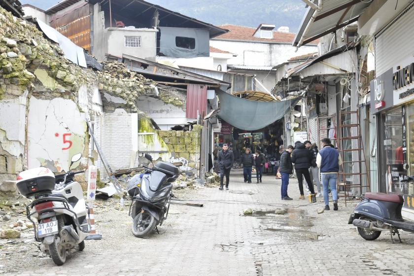 Hatay'da yıkık binaların ve dükkanların yer aldığı bir sokak