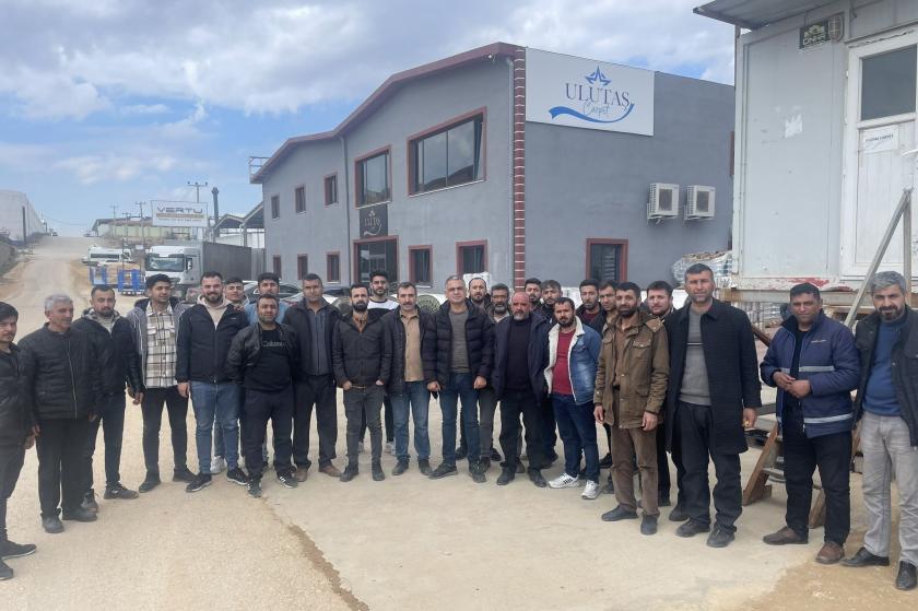 fabrika önünde poz veren işçi grubu