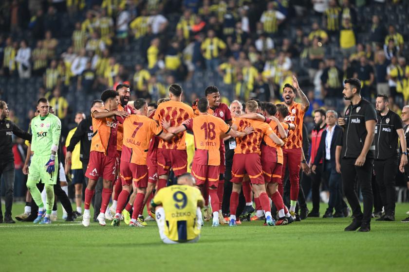 Galatasaray oyuncuları sahada seviniyor, Fenerbahçe kaptanı Edin Dzeko yerde oturuyor