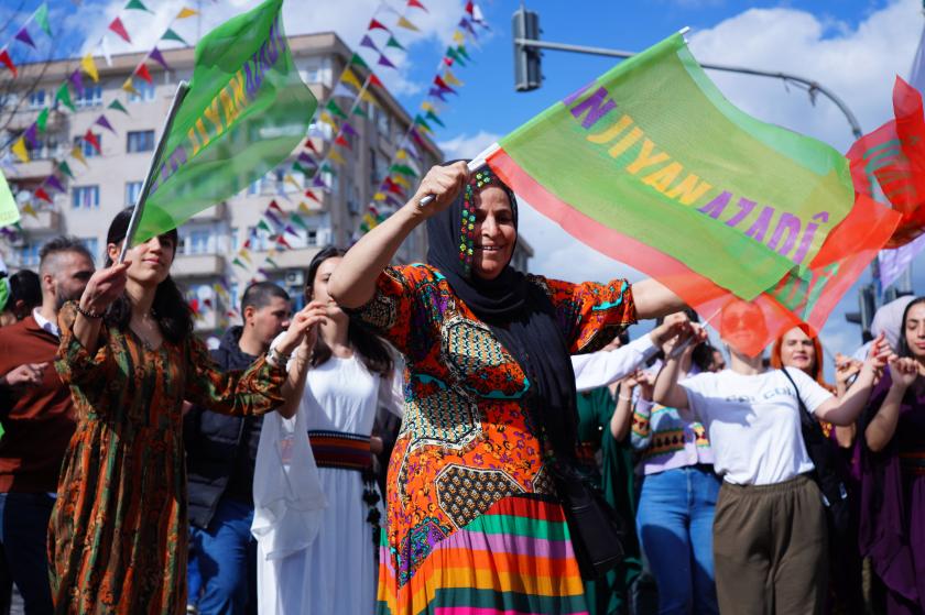 jin jiyan azadi bayrağını tutan kadın