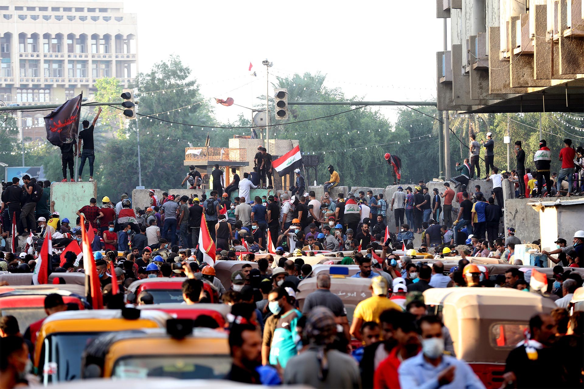 Bağdat'ta Yeşil Bölge girişine konulan beton bariyerler önünde hükümeti protesto eden Irak halkı